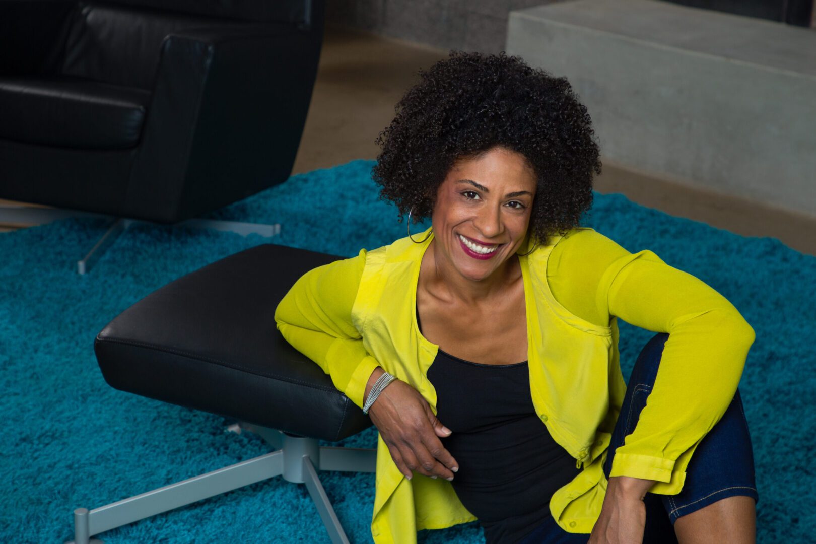 A woman in yellow jacket sitting on the ground.