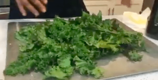 A person is cutting up some green vegetables